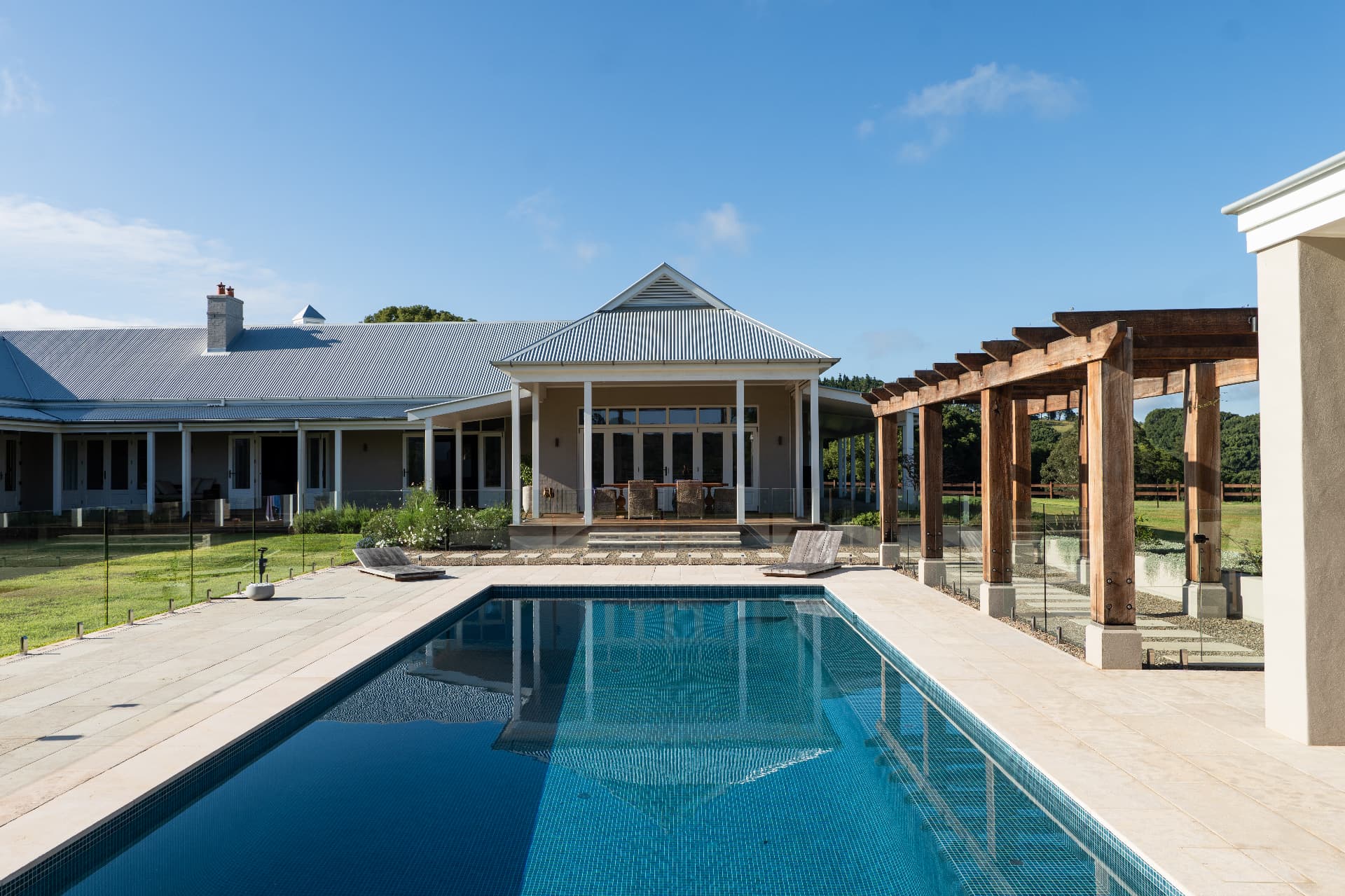 Australian homestead with wide verandah, timber pergola and tiled pool